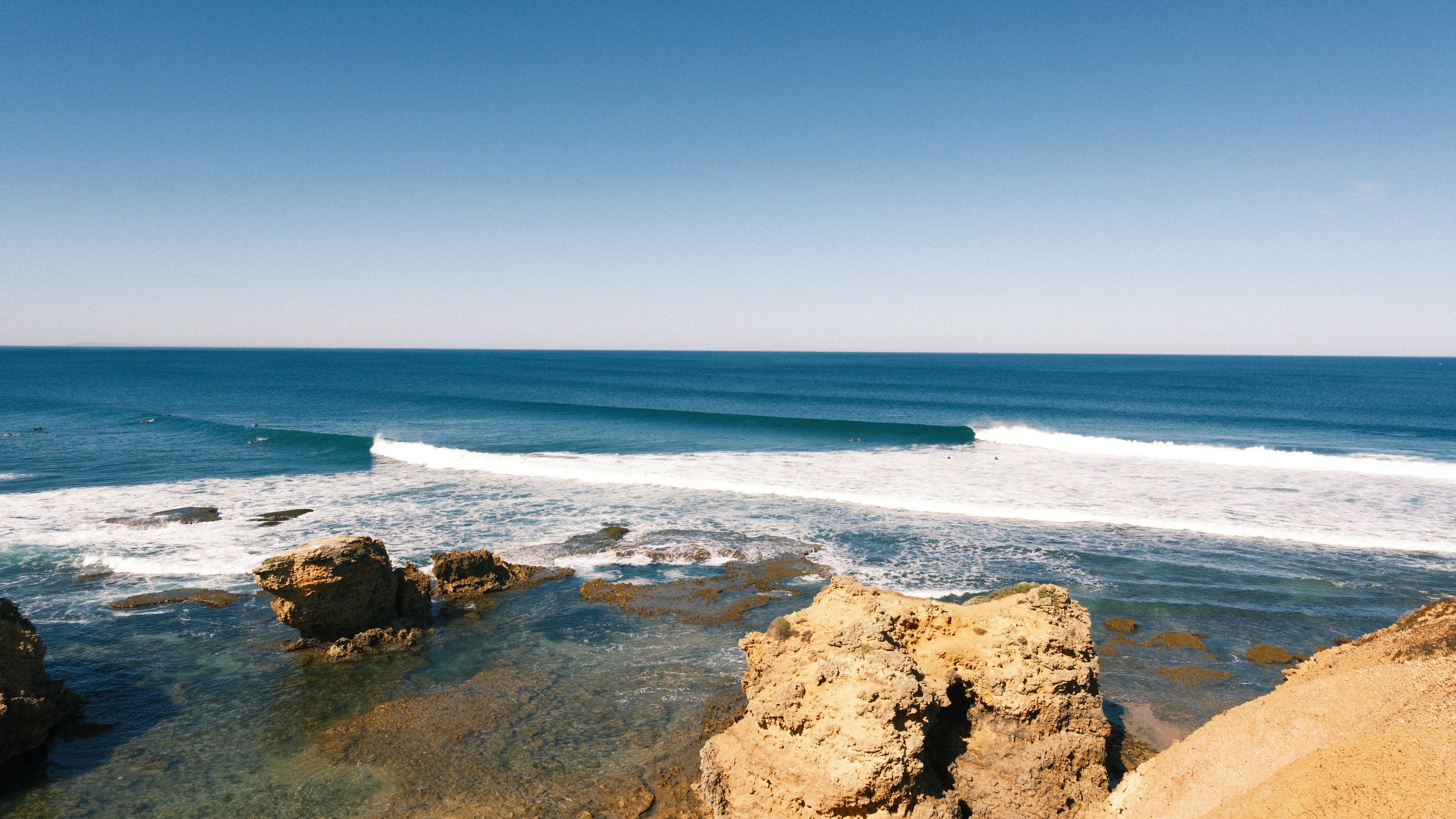 Coastline with rocks and waves under a clear blue sky